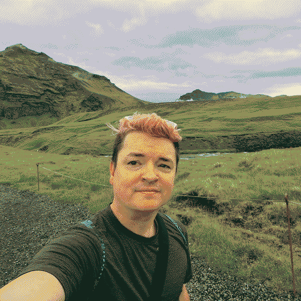 Darin taking a selfie in a green, mountainous landscape.